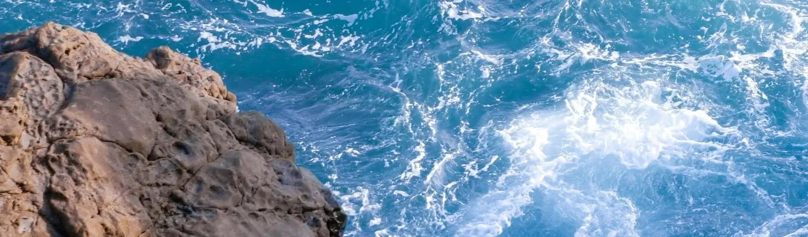 Top view of a beach with blue waves.